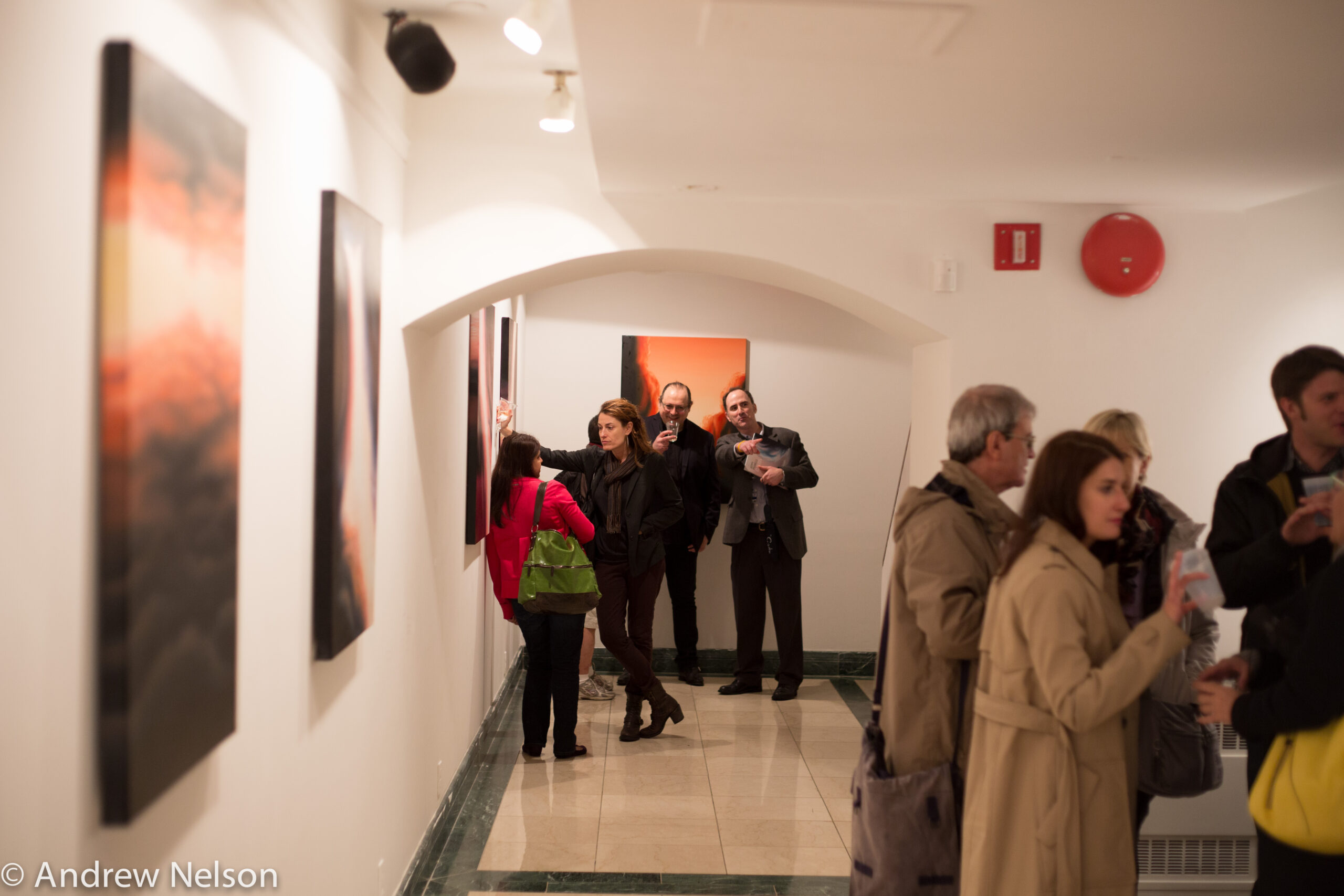 people-interacting-and-artworks-on-wall-from-exhibition-opening-geppy-pisanelli-at-casa-italiana
