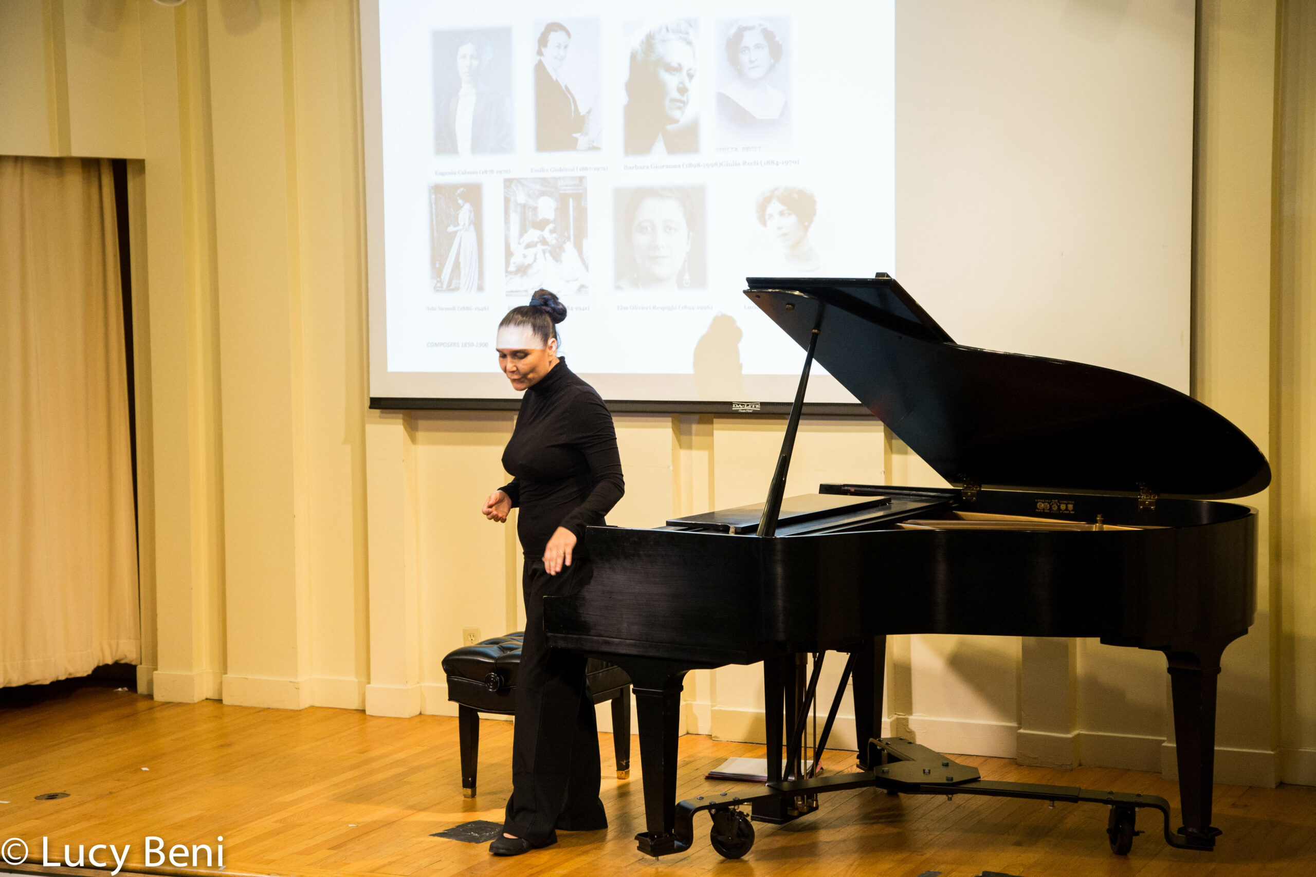 lady-standing-and-image-on-peojector-screen-from-concert-alessandra-garosi-novecento-at-casa-italiana