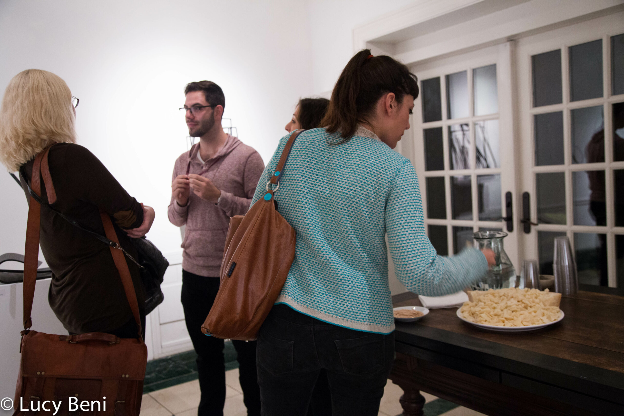 people-interacting-and-lady-having-cheese-from-exhibiton-opening-works-by-roberto-almagno-at-casa-italiana