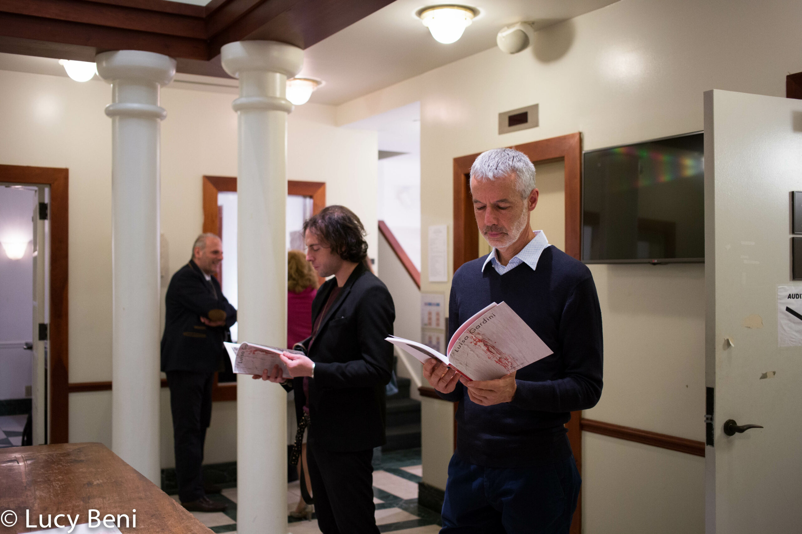 man-reading-book-from-exhibition-opening-luisa-gardini-at-casa-italiana