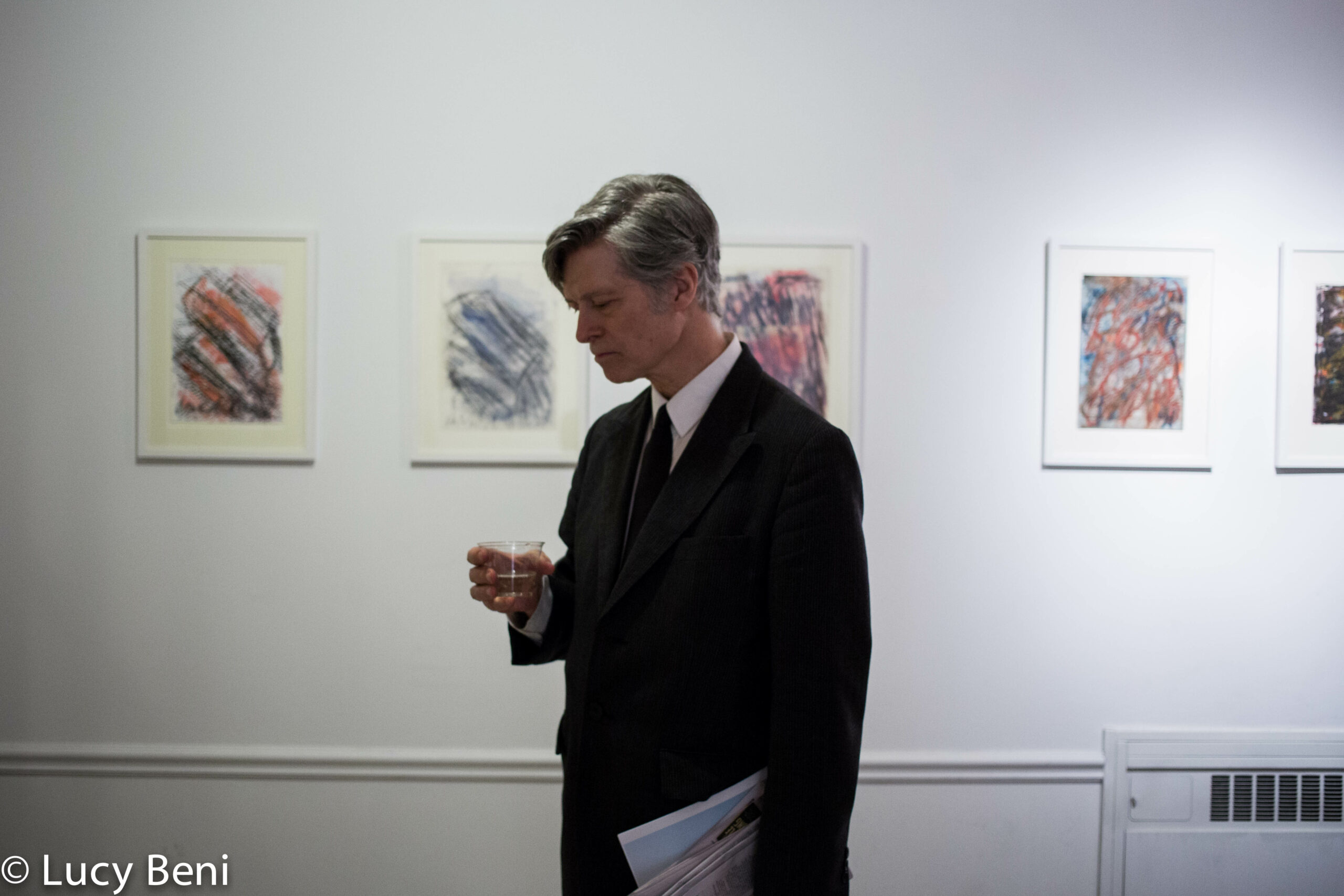 man-and-artworks-on-wall-from-exhibition-opening-luisa-gardini-at-casa-italiana