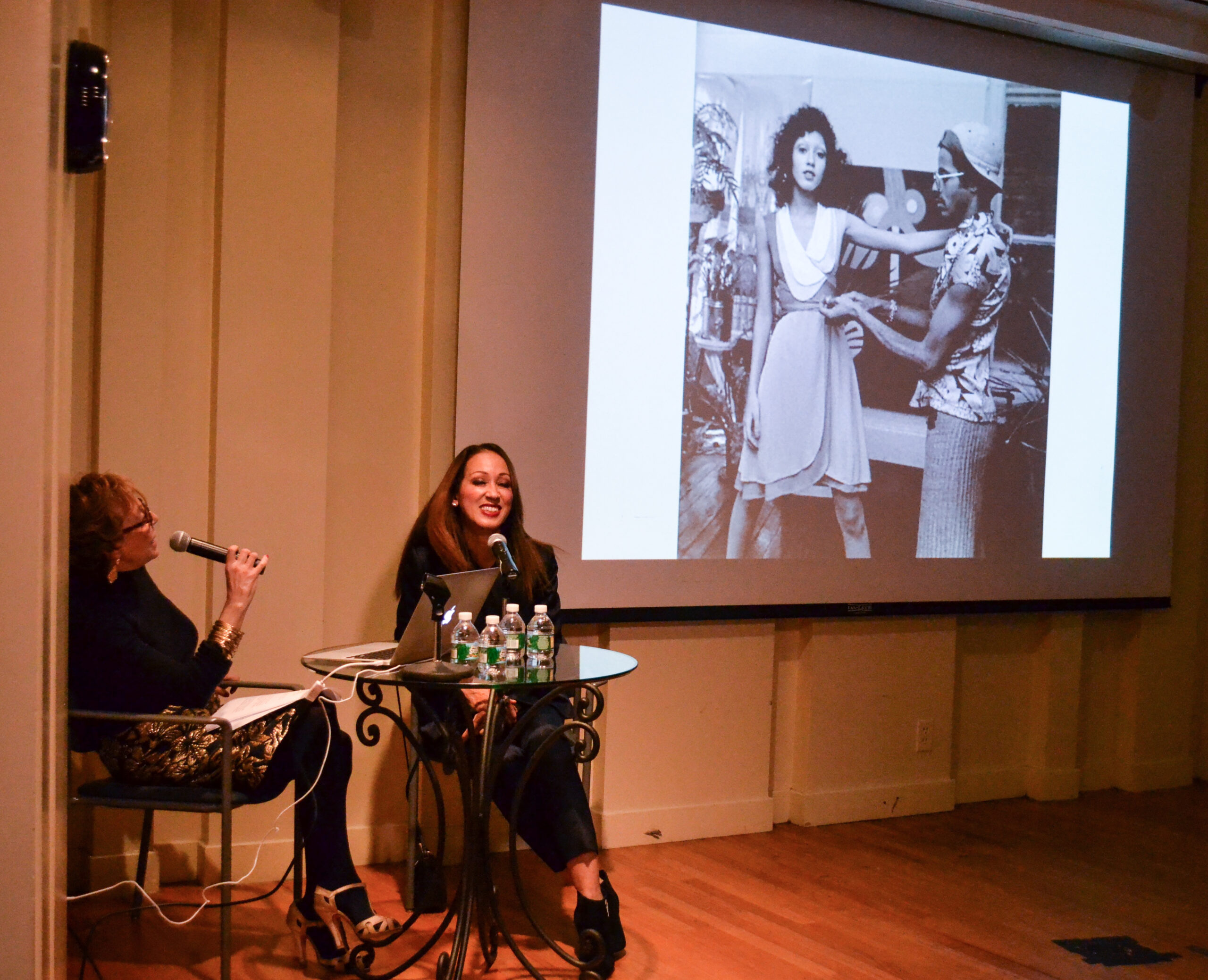 author-talking-and-image-being-displayed-on-projector-screen-from-addressing-style-pat-cleveland-at-casa-italiana