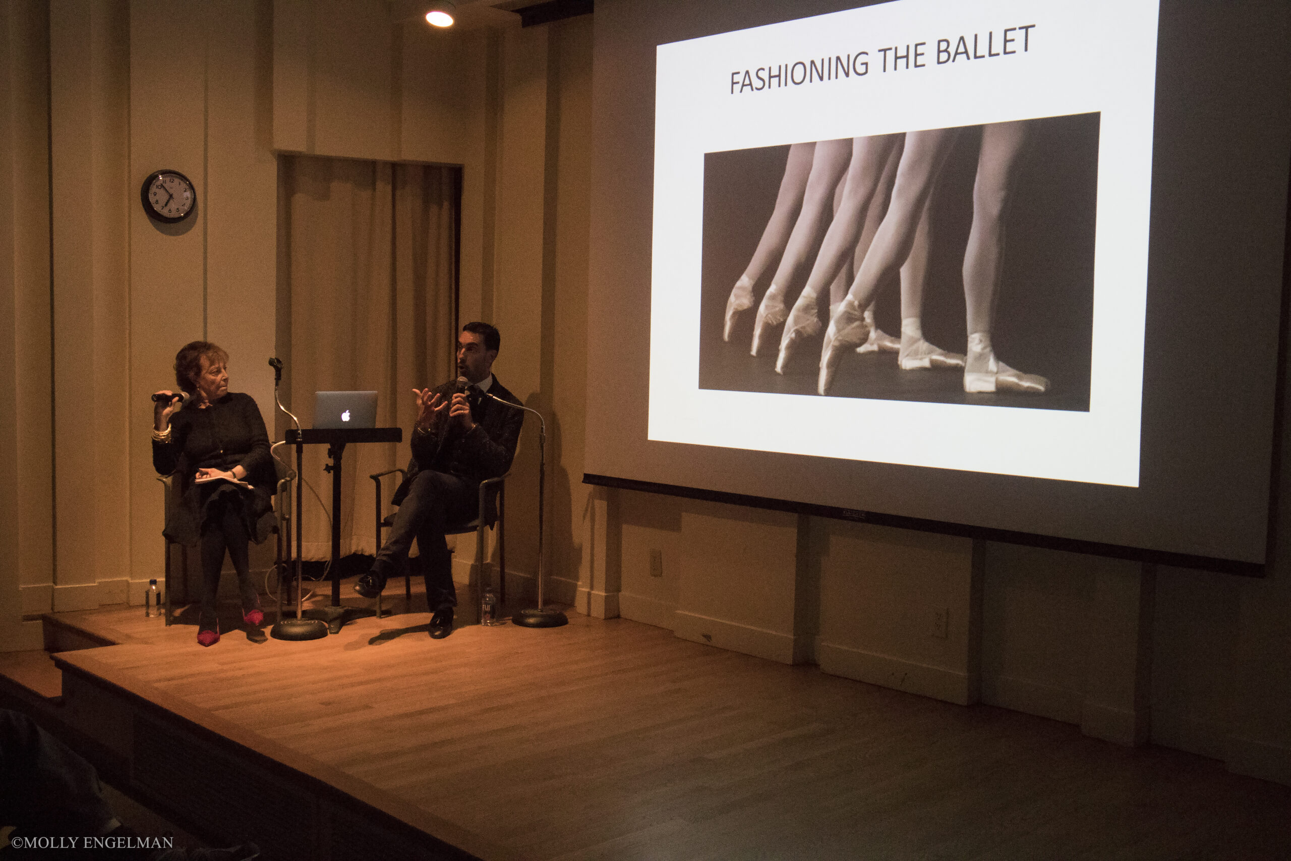 speaker-talking-and-image-displayed-on-projector-screen-from-addressing-style-fashioning-the-ballet-at-casa-italiana
