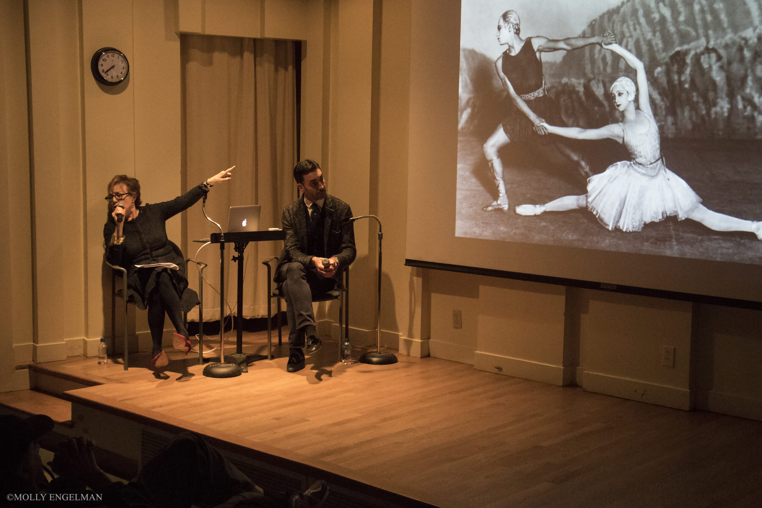 speaker-showing-image-on-projector-screen-from-addressing-style-fashioning-the-ballet-at-casa-italiana