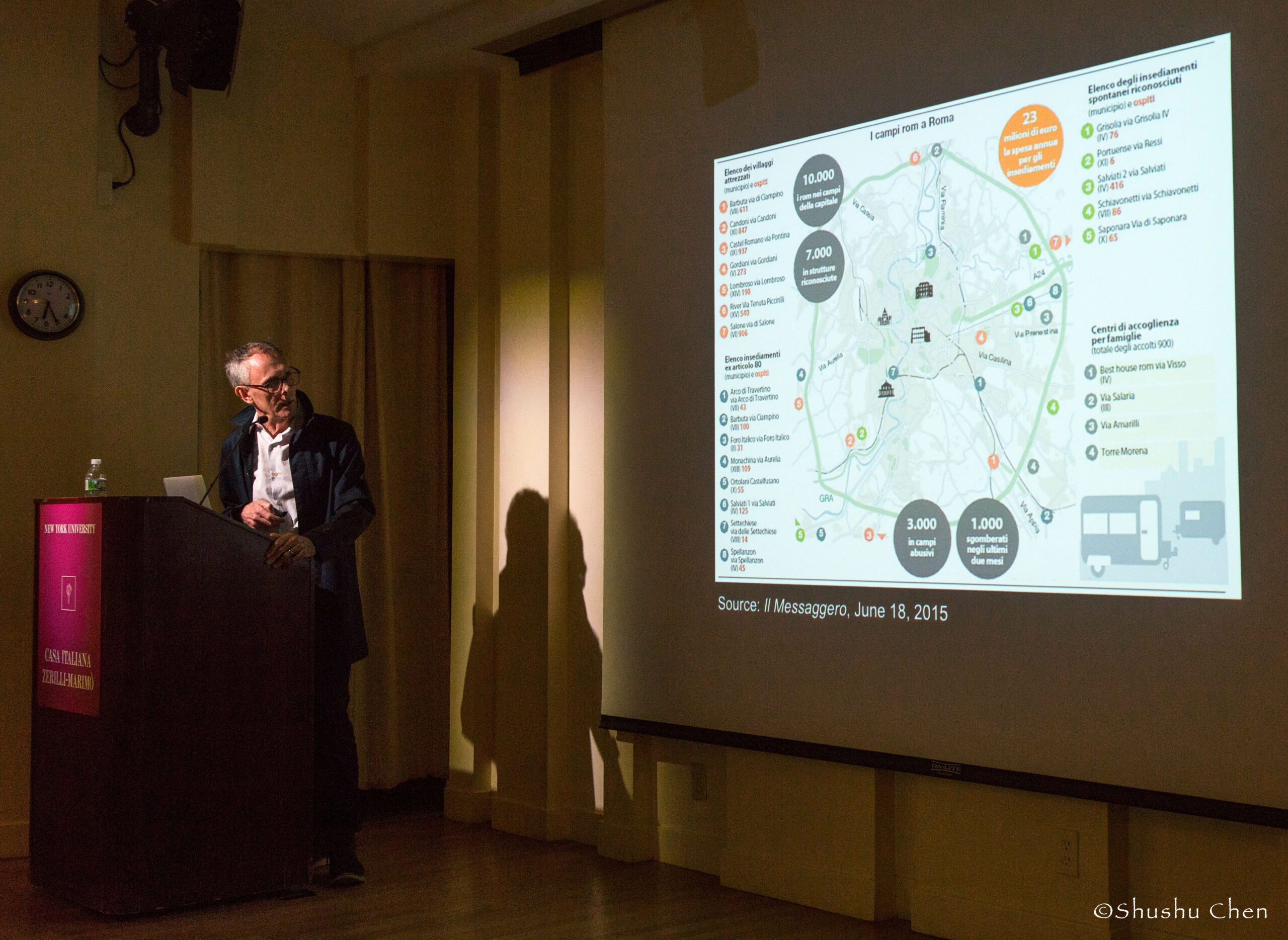 speaker-talking-image-being-displayed-on-projector-screen-from-panel-discussion-roma-migrations-at-casa-italiana