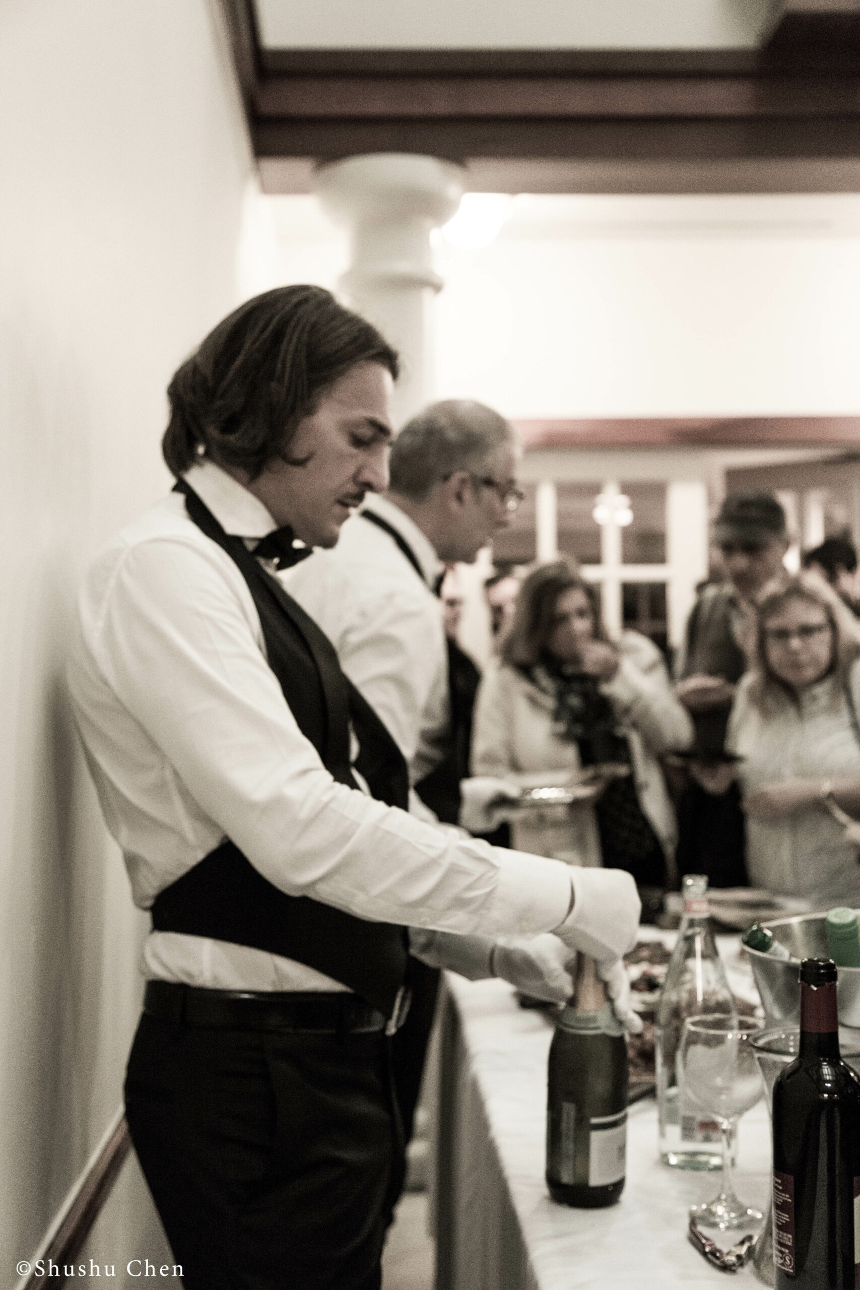 man-opening-wine-bottle-from-panel-the-babylonian-talmud-translation-project-at-casa-italiana