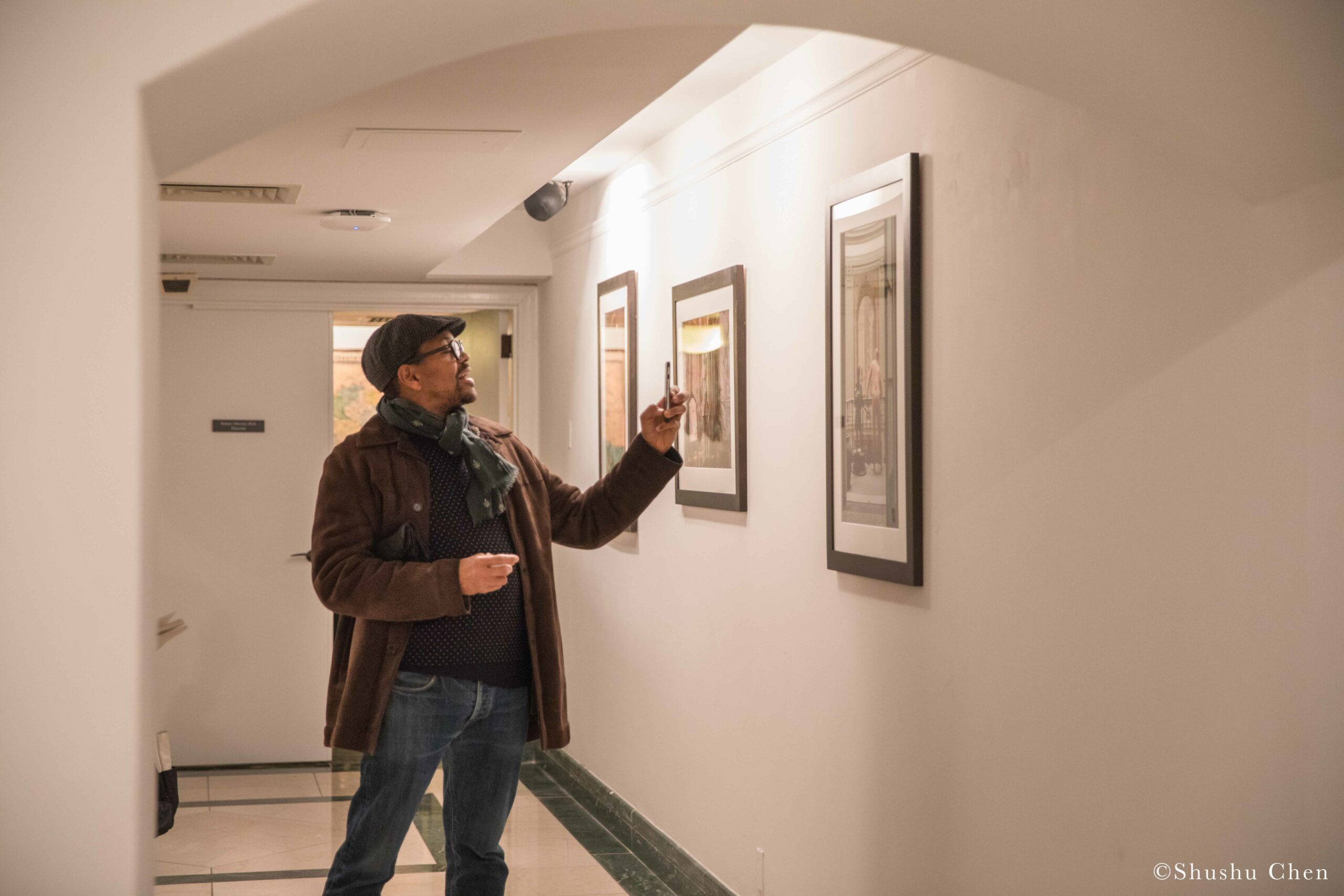 man-taking-pictures-of-artwork-from-exhibition-opening-resignifications-revisited-at-casa-italiana