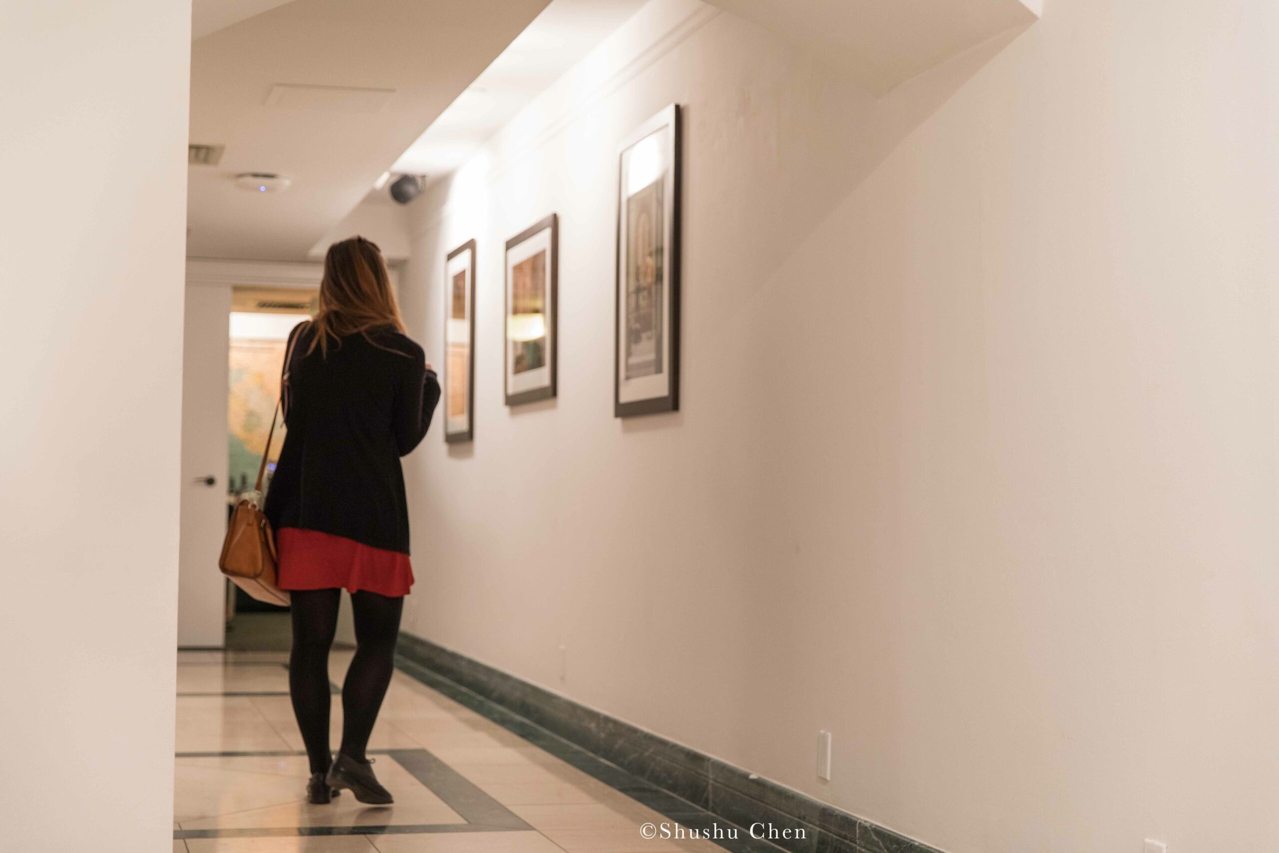 woman-seeing-artwork-on-wall-from-exhibition-opening-resignifications-revisited-at-casa-italiana