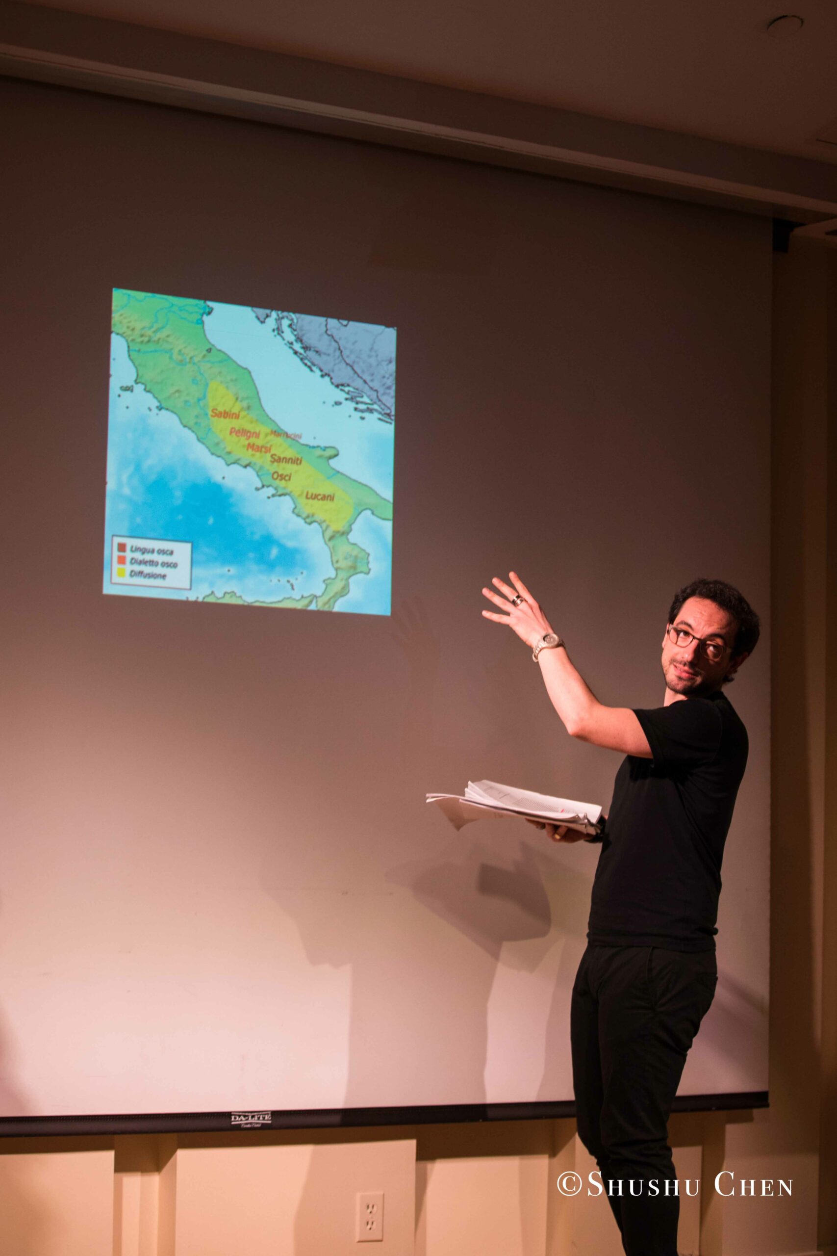 artist-showing-image-on-projector-screen-from-on-the-italian-stage-comedy-at-casa-italiana
