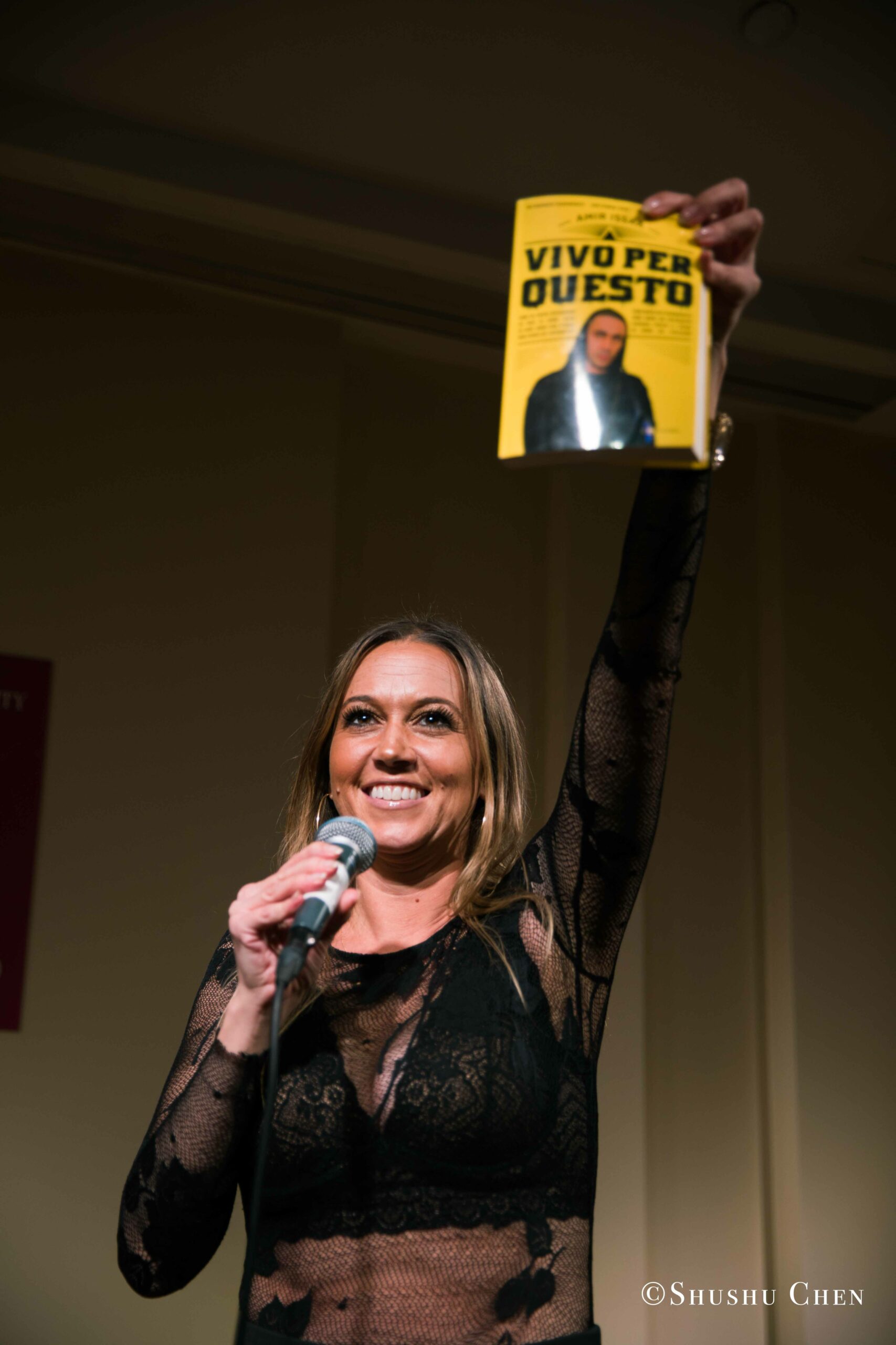 woman-with-book-in hand-smiling-from-book-presentation-and-performance-vivo-per-questo-at-casa-italiana