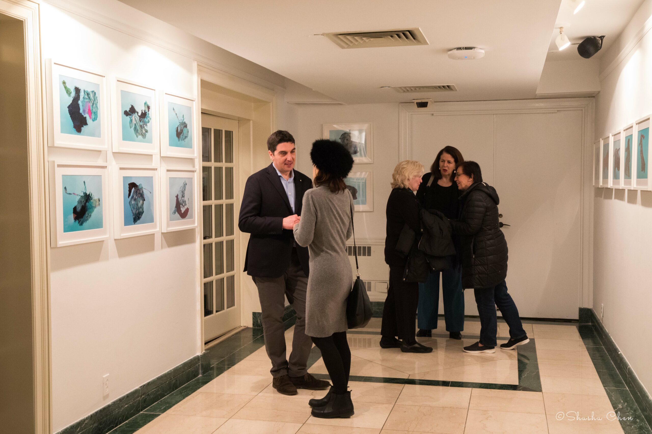 guests-conversing-and-artworks-on-wall-from-exhibition-migration-at-casa-italiana