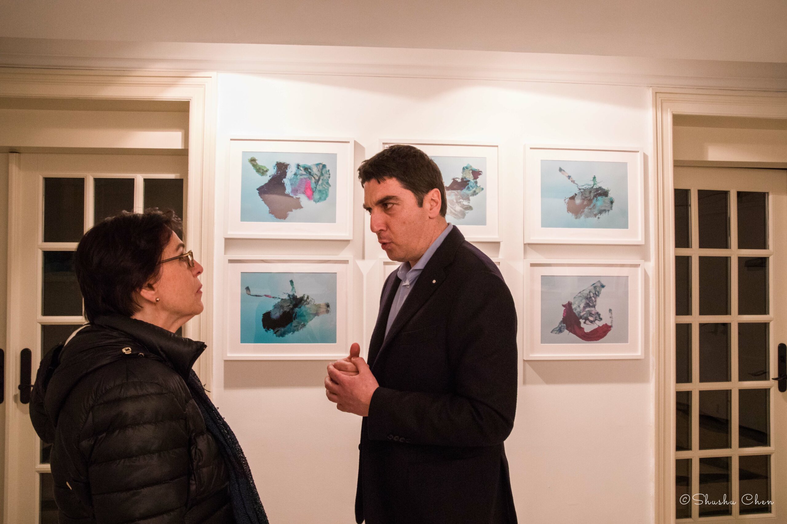 guests-conversing-and-artworks-on-wall-from-exhibition-migration-at-casa-italiana