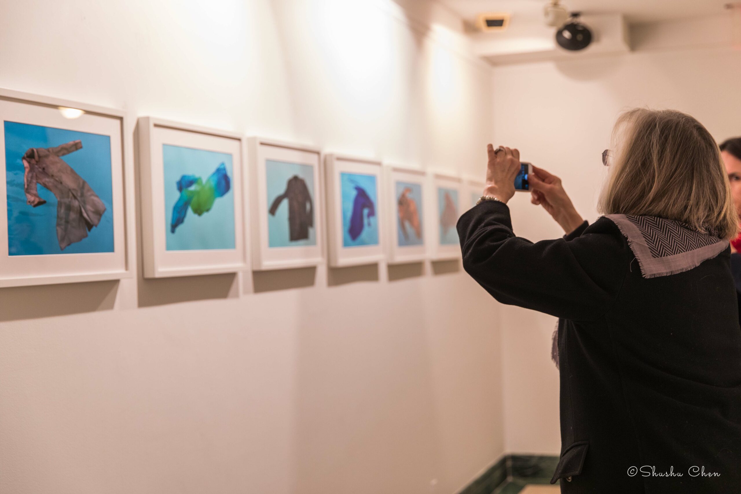 woman-taking-picture-of-artwork-on-wall-from-exhibition-migration-at-casa-italiana