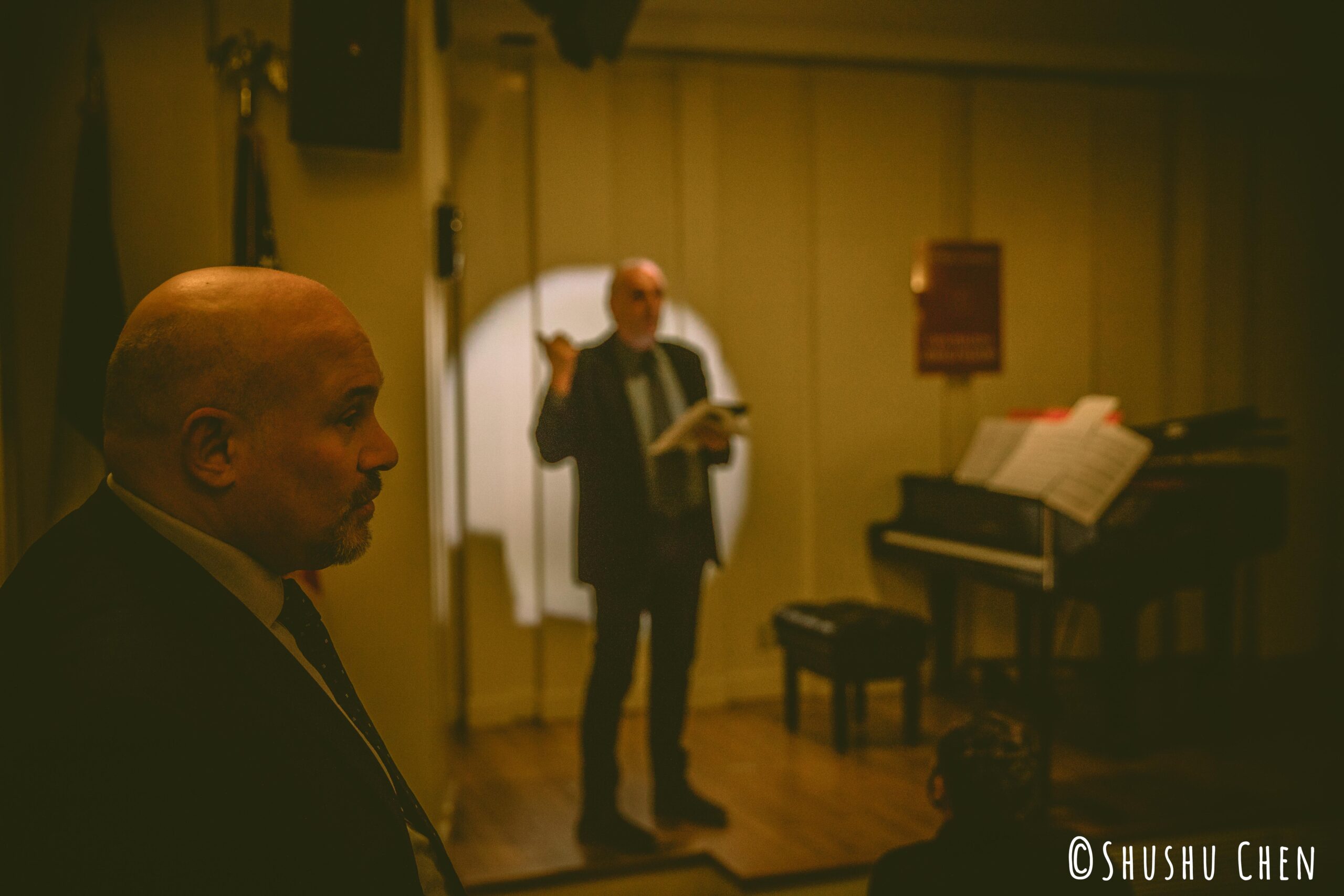 stefano-talking-and-bald-man-standing-from-concert-amen-amin-aman-at-casa-italiana