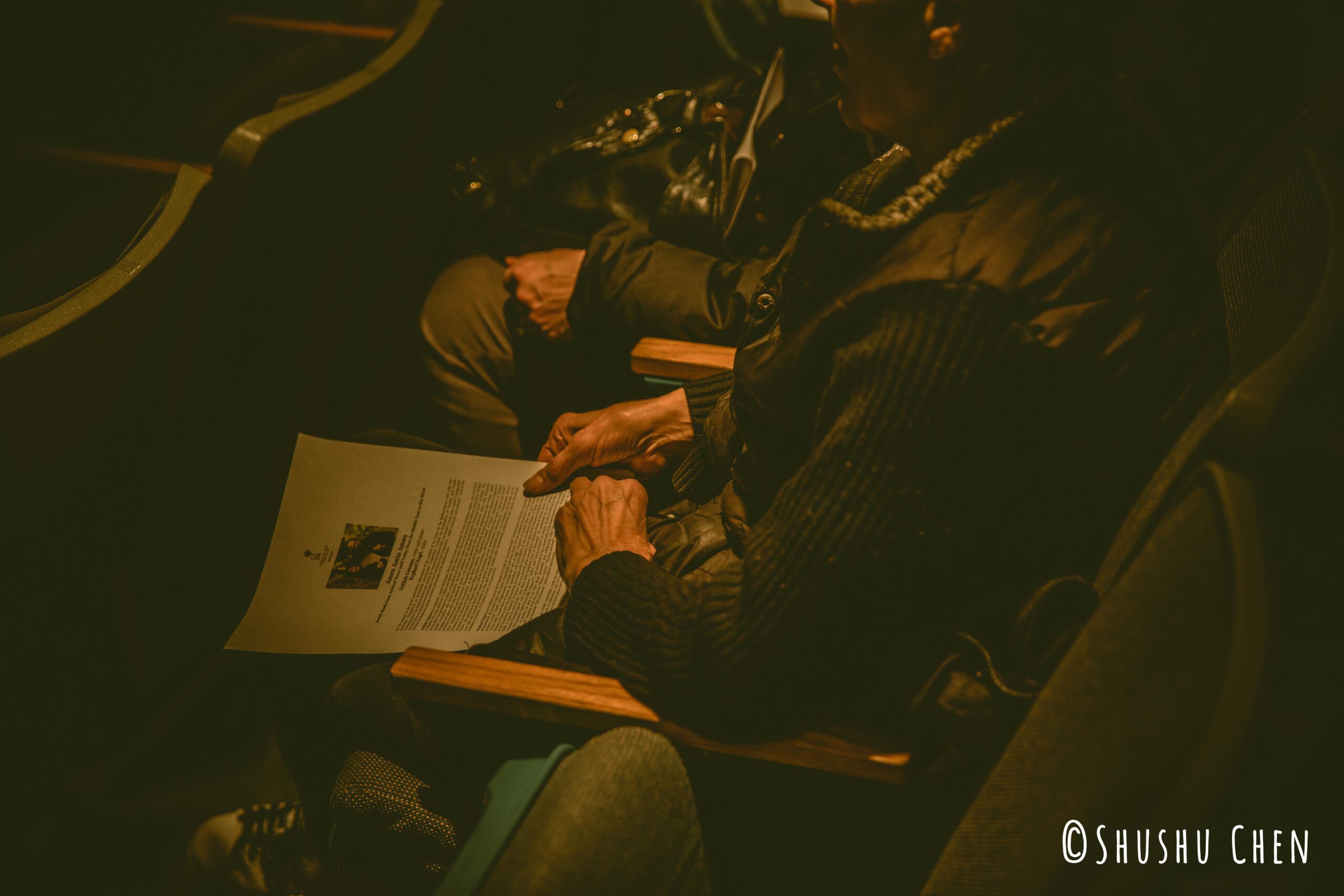 spectator-with-flyer-from-concert-amen-amin-aman-at-casa-italiana