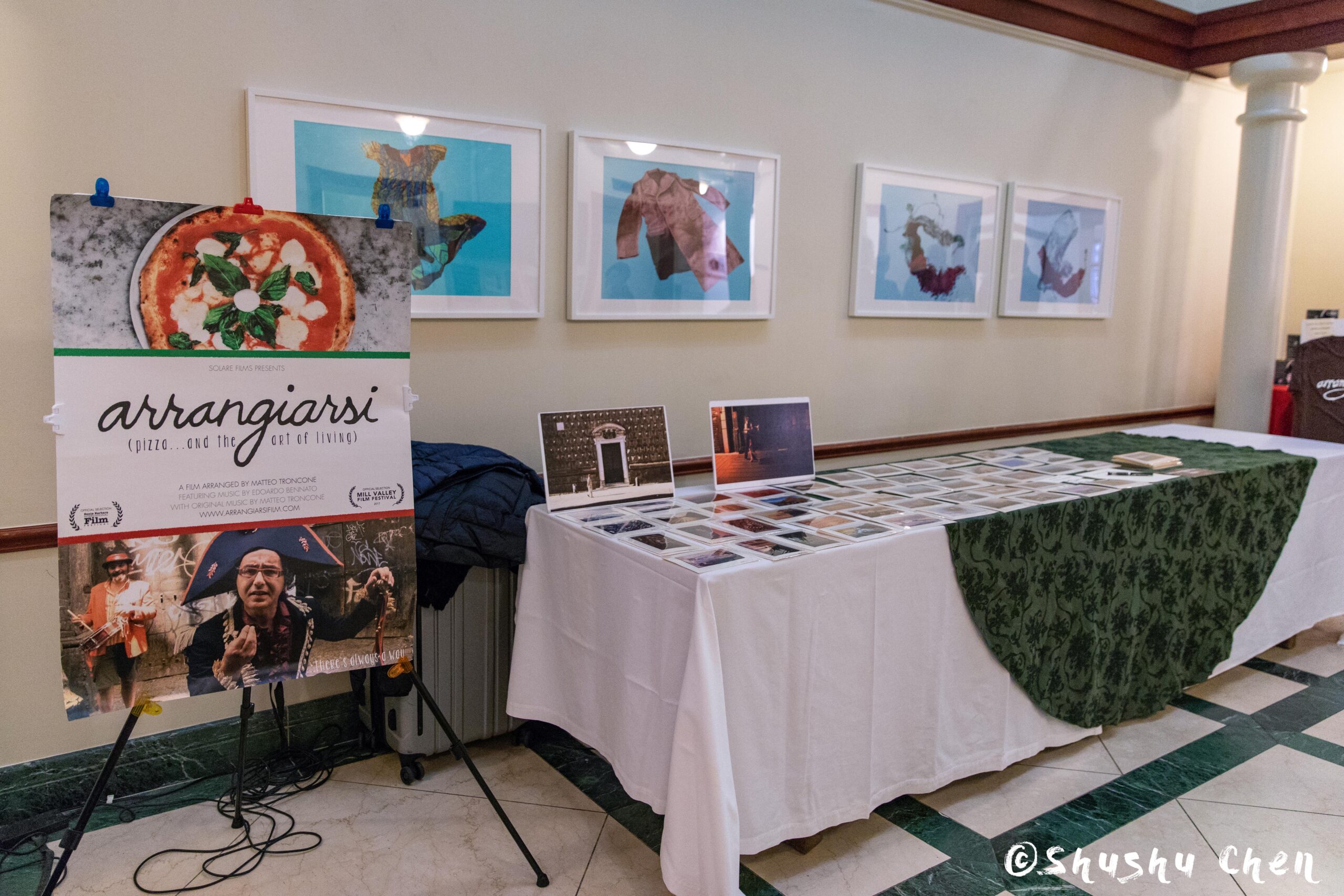 a-display-table-with-photographs-and-a-poster-advertising-from-ny-premiere-screening-of-arrangiarsi-and-presentation-at-casa-italiana