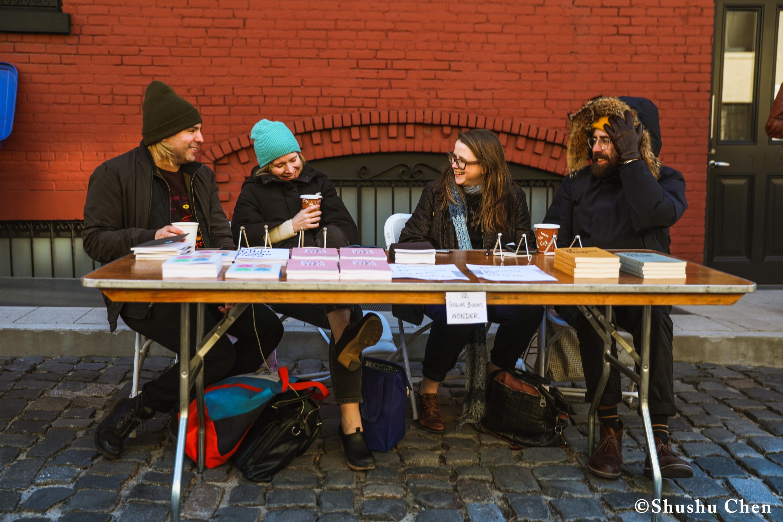 peopl-with-book-on-display-table-from-pen-world-voices-literary-mews-at-nyu