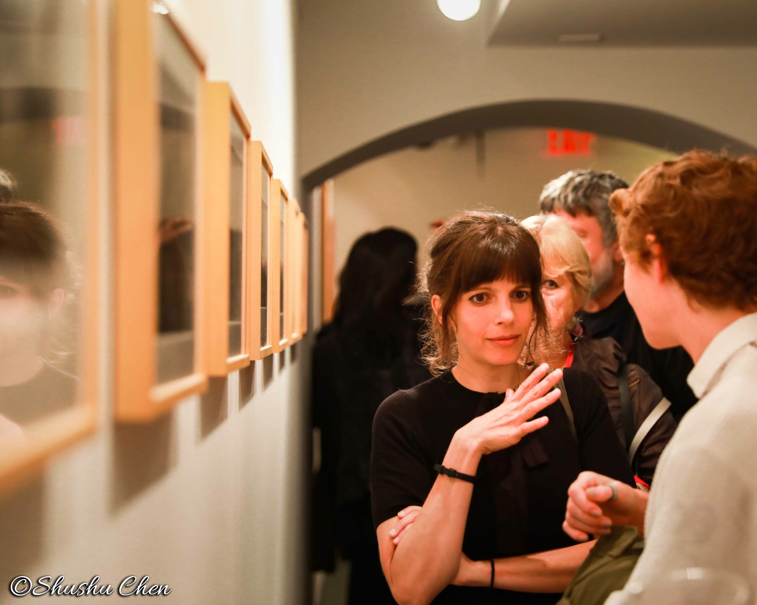 people-talking-and-seeing-artwork-on-wall-from-neorealism-and-photography-at-casa-italiana