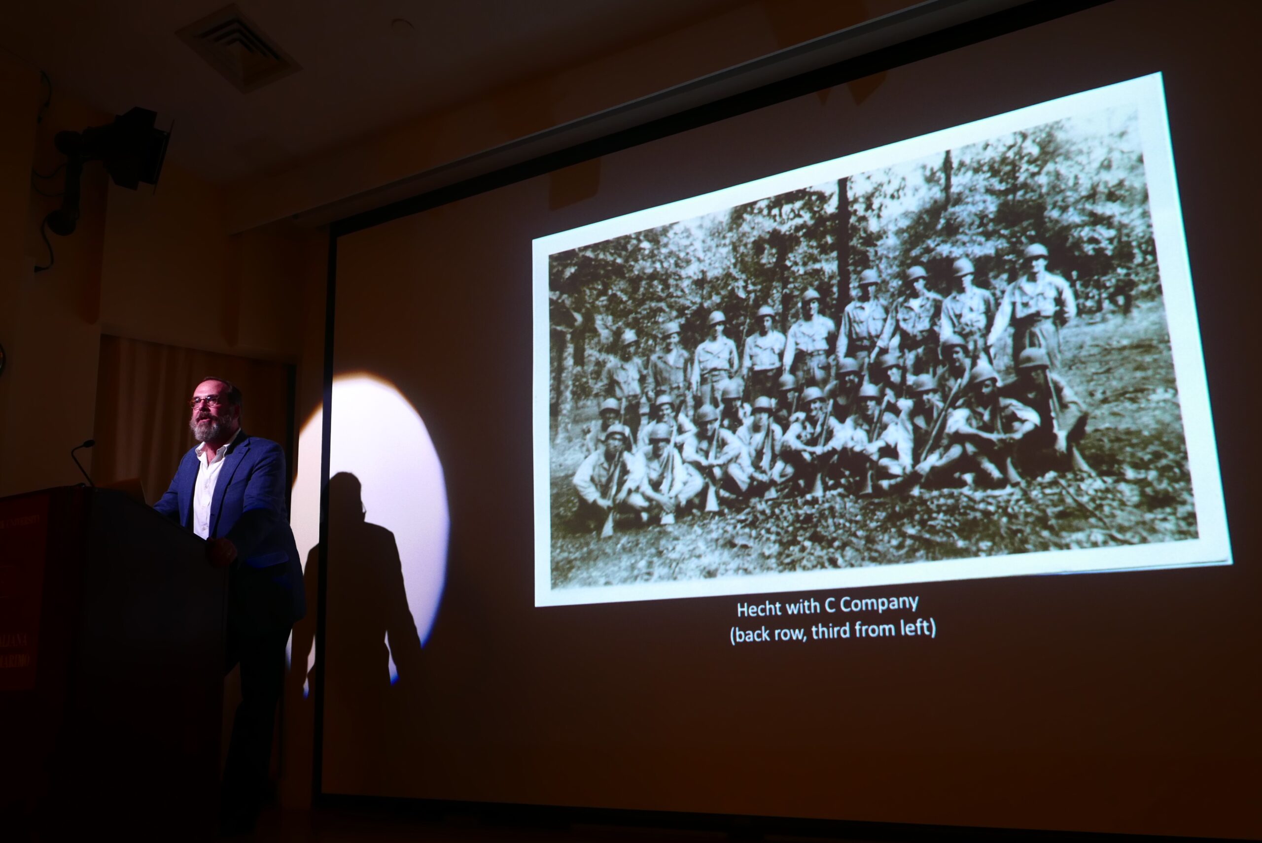 speaker-talking-and-image-being-displayed-on-projector-screen-from-anthony-hechts-italian-journey-at-casa-italiana