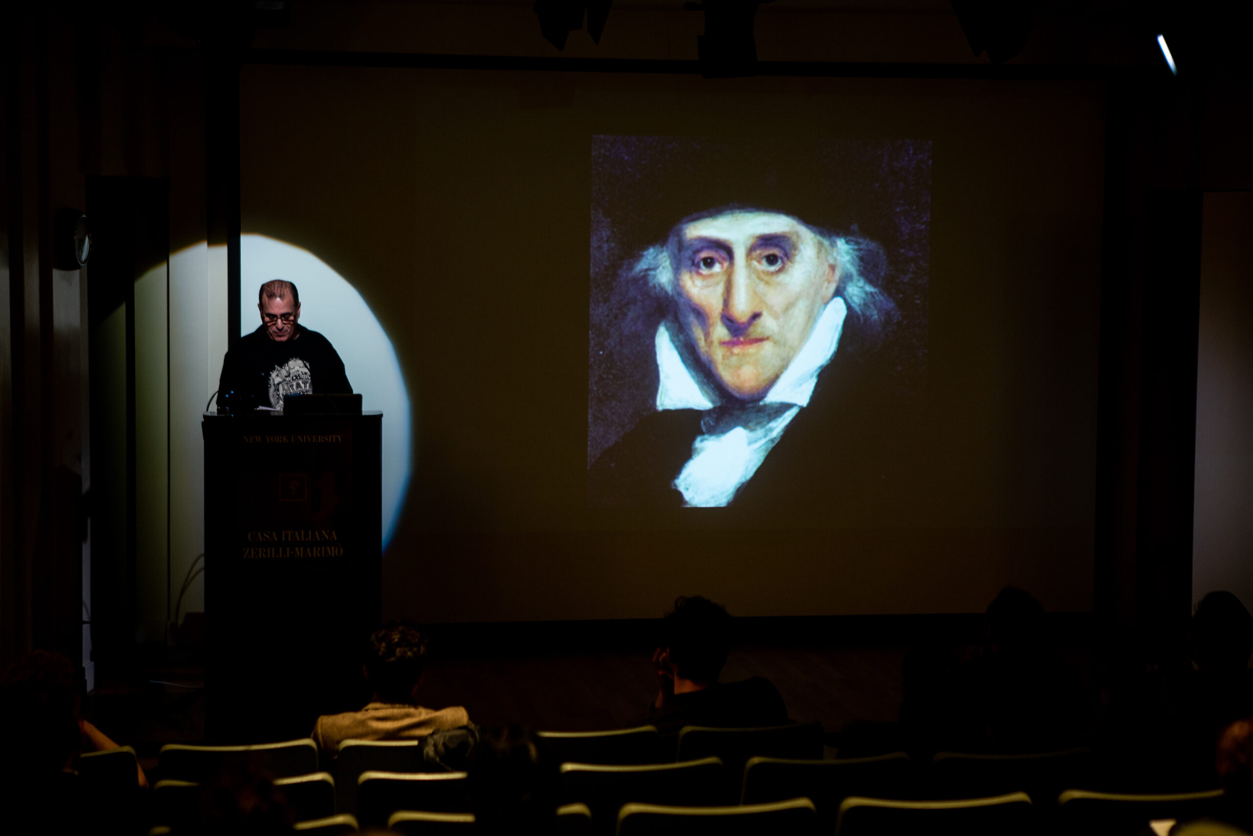 speaker-talking-and-image-being-displayed-on-the-projector-screen-from-lgbtq-in-italian-american-theater-at-casa-italiana